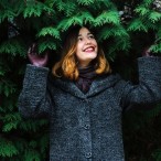 女性が笑顔で木の下にいる様子